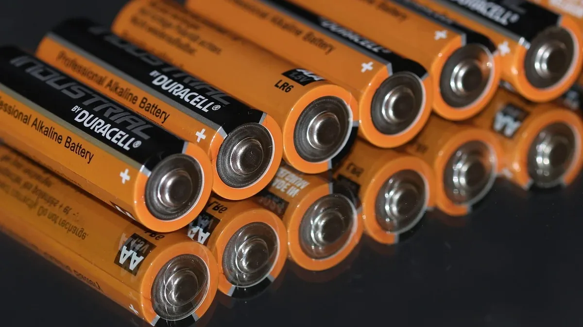 A collection of Duracell AA batteries arranged in a row, with the positive terminals facing upwards.