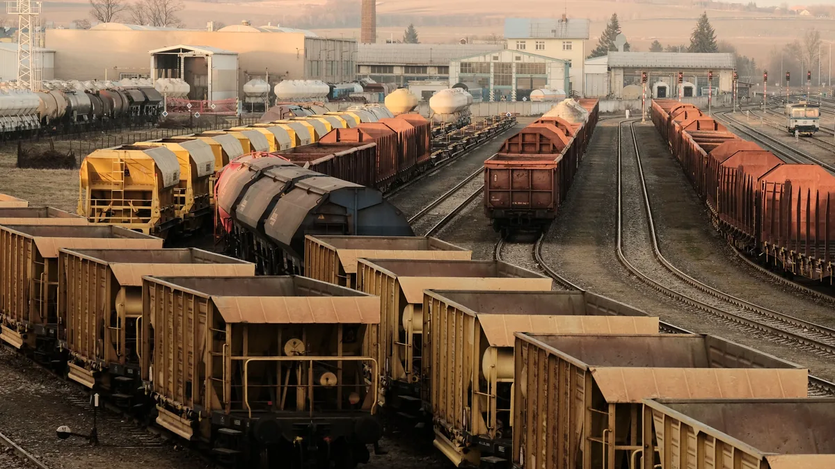 A collection of freight cars and trains in a train yard.