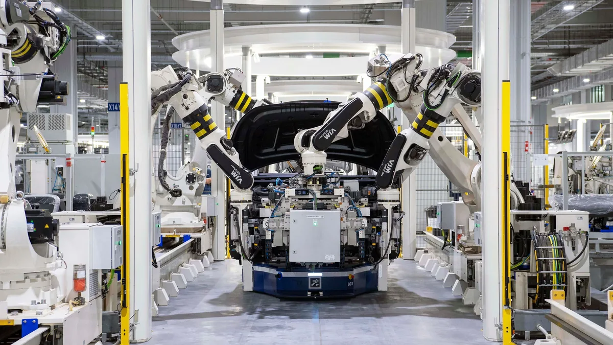 A large industrial space with a robotic arm in the center, surrounded by various machinery and equipment.