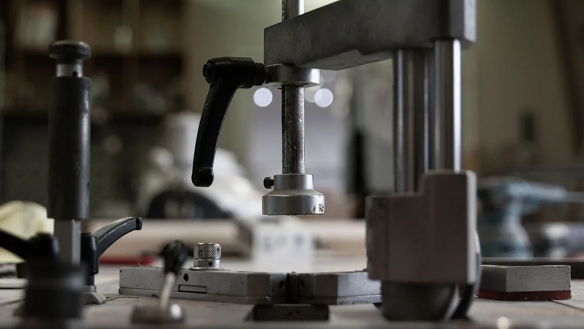 A metal press in a workshop setting, with the press being the central focus.