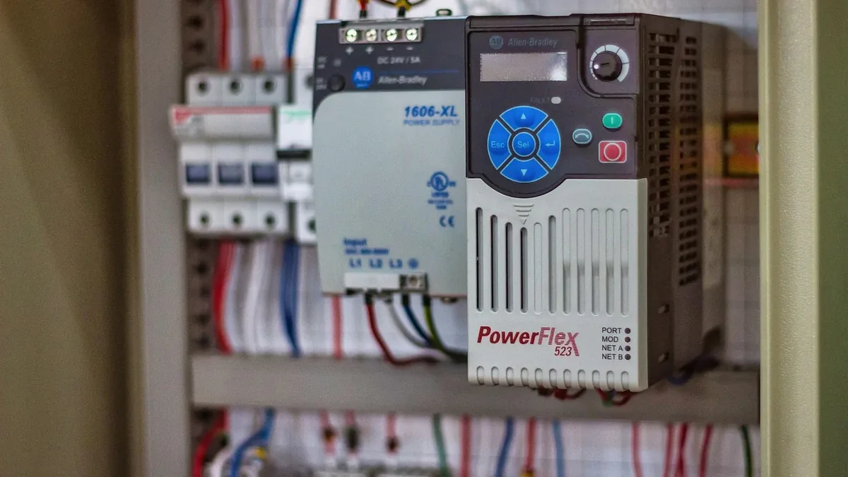 A control panel with a PowerFlex 523 AC drive and various wires and circuit breakers.