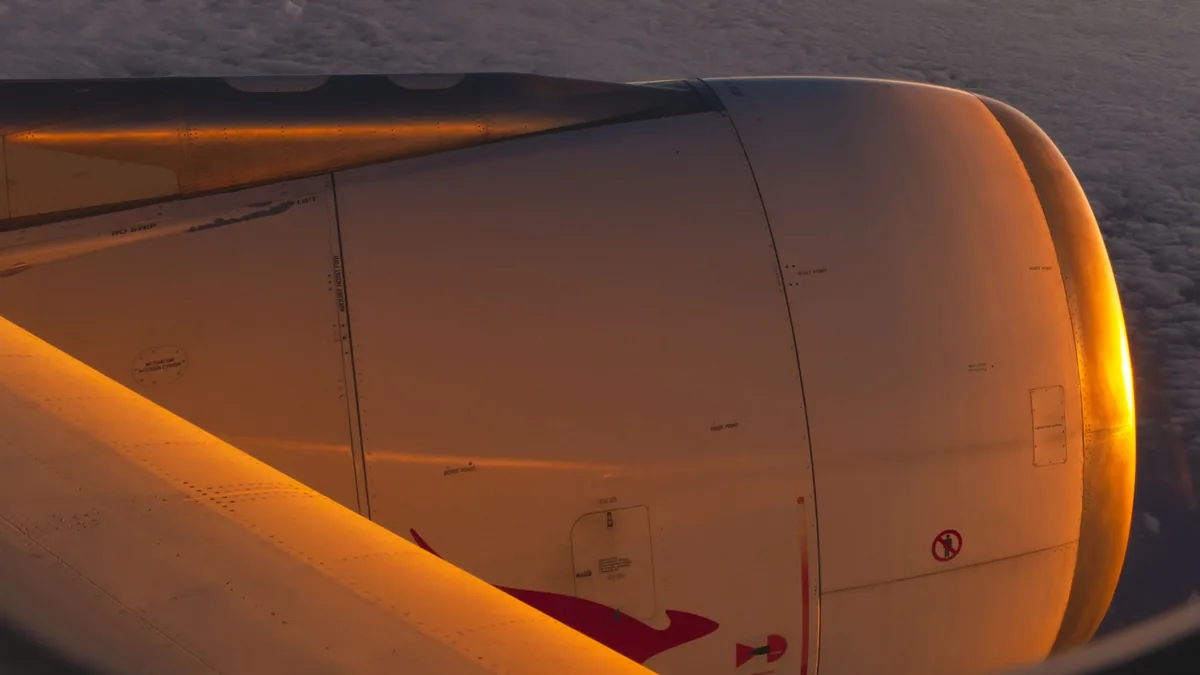 A close-up view of an airplane engine, with the engine's metal surface and red markings visible.